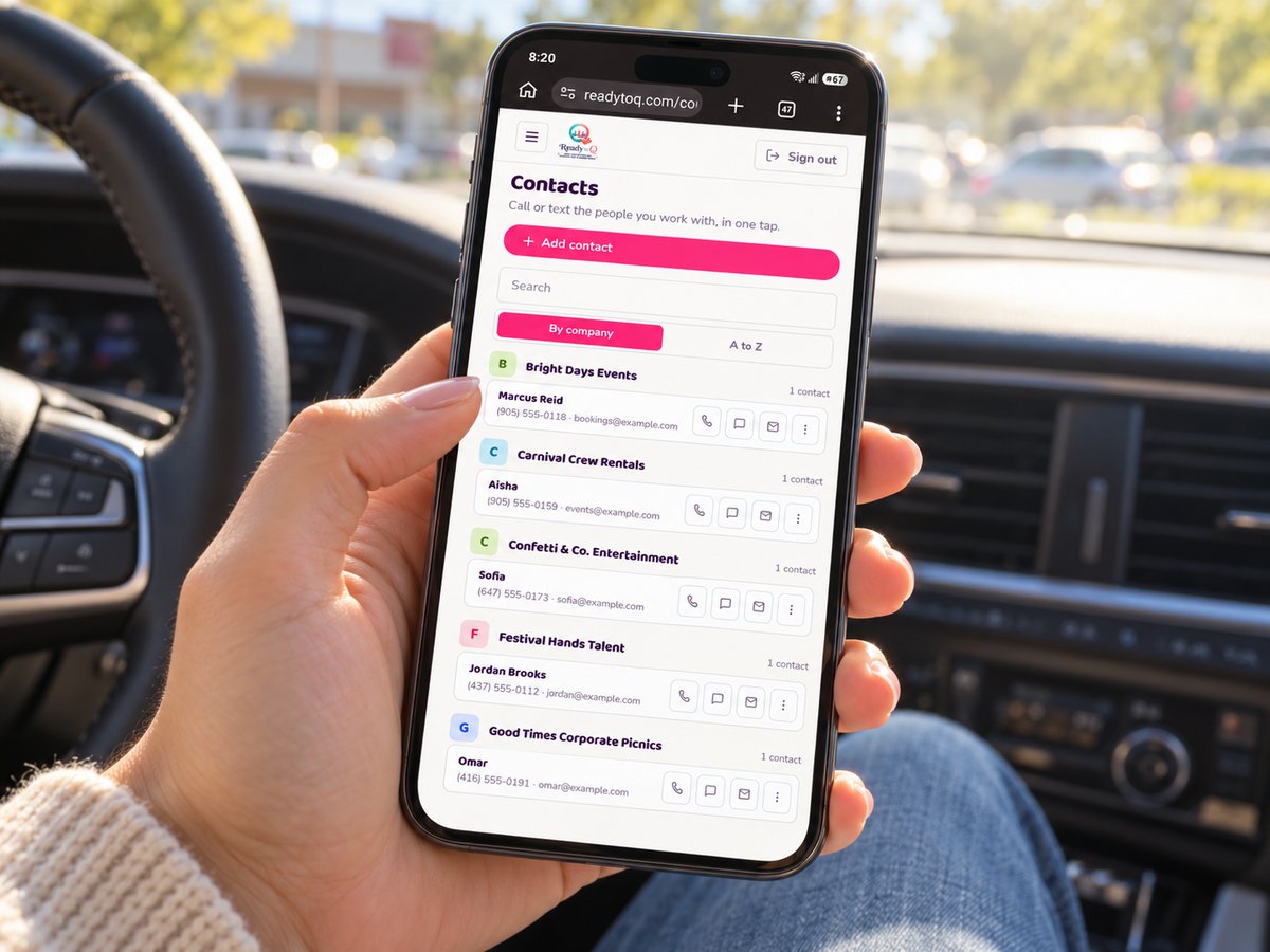 A phone held in a car showing the Contacts page: companies as headings with a coloured initial, each with the people at that company underneath, their number and email, and small buttons to call, text or email.